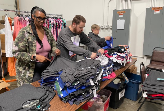 Rakeeta Johnson, left, training specialist at St. Coletta's of Illinois in Tinley Park, leads a team of volunteers from its Community Day Services program as they hang clothing for My Joyful Heart, a nonprofit children's charity in Mokena. (St. Coletta's of Illinois)