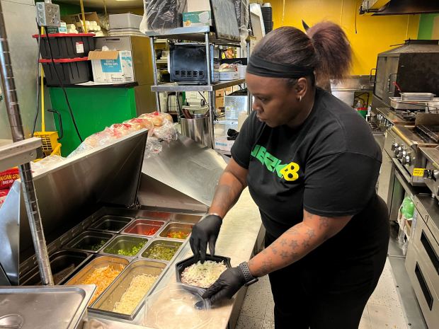 Jackie Marshall, an employee at Jerk 48, prepares a meal July 18, 2024. Jerk 48 is offering reduced price meals until the end of July to support those who have been affected by recent storm activity. (Samantha Moilanen/Daily Southtown)