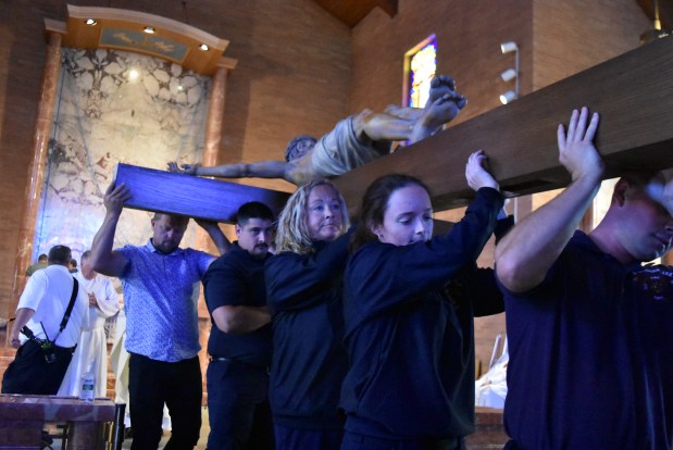 The crucifix is moved out of St. Bernadette's Church June 30, 2024, to be delivered across town. (Jesse Wright/for the Daily Southtown)