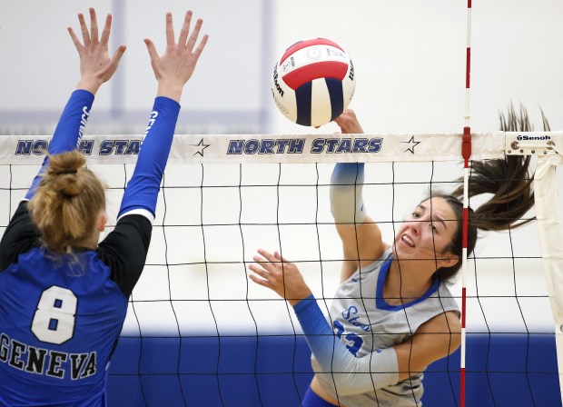 St. Charles North's Haley Burgdorf (23) goes for a kill past Geneva's Lillian Hallahan (8) during a DuKane Conference match in St. Charles on Tuesday, Oct. 17, 2023.