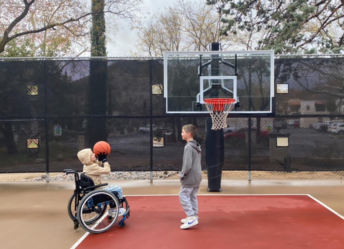 This undated photo provided by Jasculca Terman Strategic Communications shows twin brothers Cooper and Luke Roberts playing basketball. Cooper was a victim of the 2022 Fourth of July parade shooting in Highland Park, Ill., and remains paralyzed from the waist down. Keely Roberts, the mother of the youngest victims of the Fourth of July parade shooting, which left one of her twin sons now 10 paralyzed from the waist down, will talk to the media Wednesday, July 3, 2024, about what it means to survive the horror two years later. (The Roberts Family/Jasculca Terman Strategic Communications via AP)
