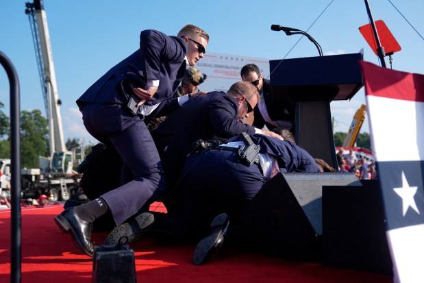 Republican presidential candidate former President Donald Trump is covered by U.S. Secret Service agents at a campaign rally on July 13, 2024, in Butler, Pa. (Evan Vucci/AP)