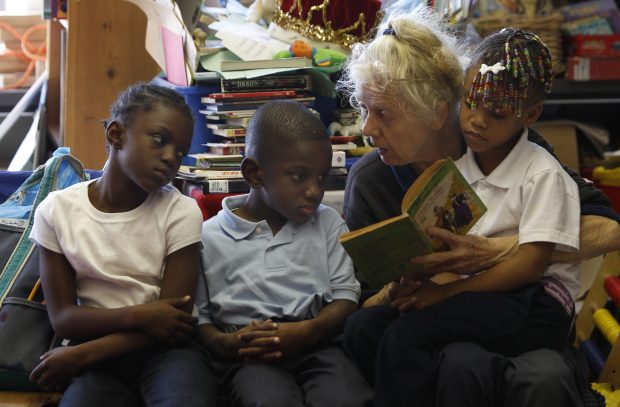 Sue Duncan reads Helen Keller's book about blindness to Ashunti, from left, Jaylen and Breah during an after-school program at Jackie Robinson Elementary School on the South Side in 2010. (Nuccio DiNuzzo/Chicago Tribune)