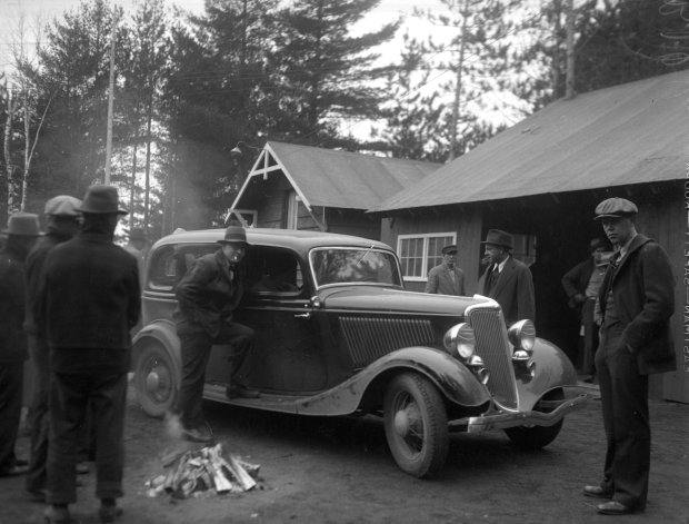 Government men stand by the Ford that was abandonded by John Dillinger during a gun battle between authorities and Dillinger's gang at the Little Bohemia Resort on April 22, 1934 in Manitowish Waters, Wisconsin. FBI agents had surrounded the lodge, but Dillinger and his gang were able to escape along the shore of the nearby lake. (Chicago Herald and Examiner historical)