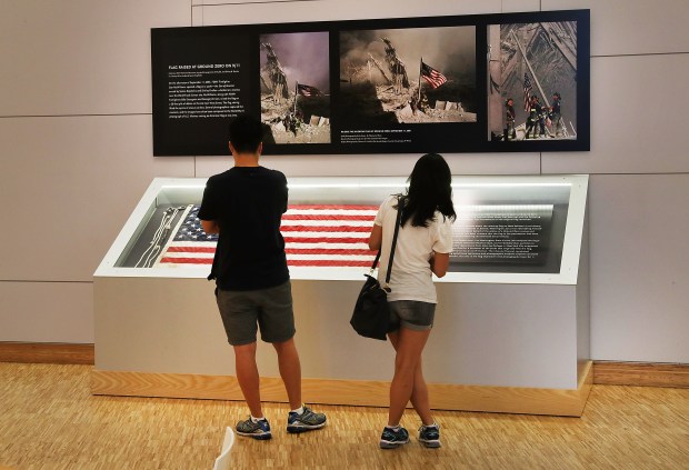 The American flag that was raised by firefighters above the site of the 9/11 attacks on the World Trade Center in New York in 2001 is displayed at the National Sept. 11 Memorial & Museum along side the iconic photos of the firefighters raising it on the day of the attacks. (Spencer Platt/Getty Images)