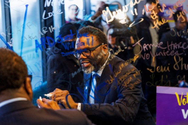 Then-mayoral candidate Brandon Johnson signs a mirror during a stop at 6th Ward aldermanic candidate William Hall's campaign office in Chicago on April 2, 2023. (Armando L. Sanchez/Chicago Tribune)