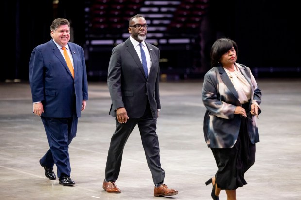 Gov. J.B. Pritzker, Mayor Brandon Johnson and convention chair Minyon Moore arrive to speak during a walkthrough of the Democratic National Convention on May 22, 2024, at the United Center. (Brian Cassella/Chicago Tribune)