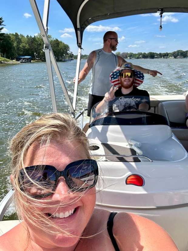 During his first time driving a boat, Braiden Bergum takes a spin around Lake Camelot with his mom, Megan Bergum, front, and her partner, Michael Domke, during a Dove's Nest stay in Aug. 2023. (Megan Bergum)