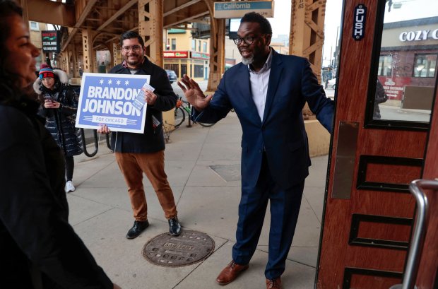 Ald. Carlos Ramirez Rosa, center, joins then Chicago mayoral candidate Cook County Commissioner Brandon Johnson as they greet commuters while campaigning at the California CTA Blue Line stop on Feb. 15, 2023. (Antonio Perez/ Chicago Tribune)