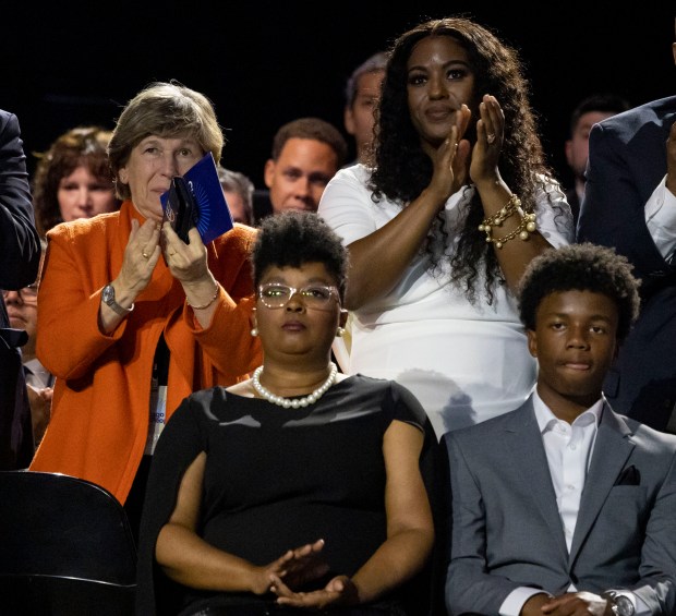 Randi Weingarten, left, president of the American Federation of Teachers, and Chicago Teachers Union President Stacy Davis Gates stand and applaud as Mayor Brandon Johnson speaks during his inauguration, May 15, 2023, at the Credit Union 1 Arena. Seated are Johnson's family members. (Brian Cassella/Chicago Tribune)