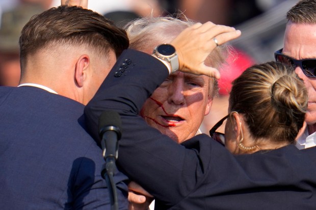 Former President Donald Trump is helped off the stage by U.S. Secret Service agents at his campaign event in Butler, Pennsylvania, on July 13, 2024. (Gene J. Puskar/AP)