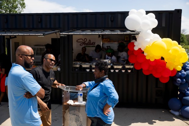 Michael Floyd, from left, Derrick Faulkner and Ald. Monique Scott, 24th, talk during the grand opening of Sheila's @ Douglass 18, June 29, 2024, in Douglass Park. (Vincent Alban/Chicago Tribune)