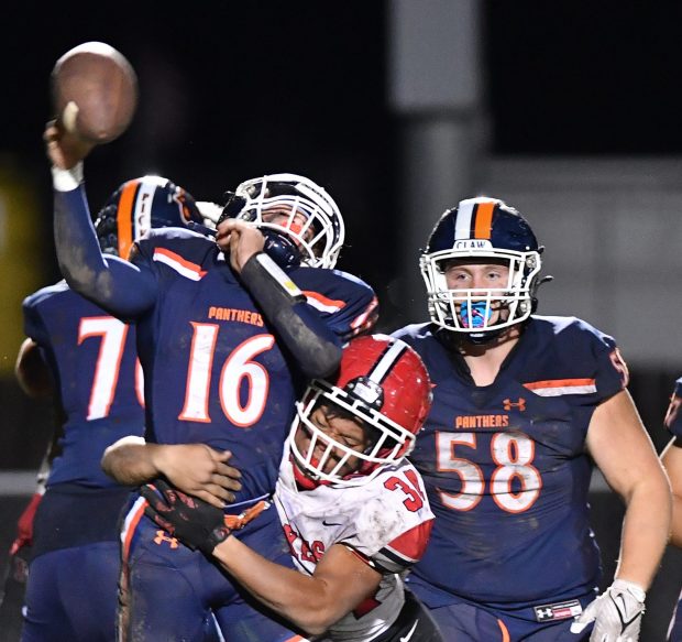 Yorkville's Jamarion Kenniel makes a jarring hit on Oswego quarterback Brett Connolly causing an incomplete pass during a game in Oswego on Friday, Oct. 6, 2023...(Jon Cunningham for The Beacon-News)