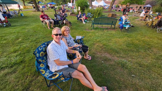 Barbara and William Densmore of North Aurora relax near the stage Friday night at the annual North Aurora Days festival at Riverfront Park. (David Sharos / For The Beacon-News)