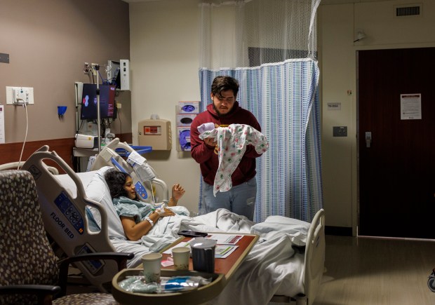 Fabián Méndez, 20, stands next to his girlfriend Yolexi Cubillan, 19, both from Venezuela, while holding their newborn Derick Alexander Cubillan at the University of Chicago Medical Center Sunday, Sept. 3, 2023 in Chicago. Yolexi gave birth to Derick around 10 a.m. after she went into labor on Saturday. Yolexi and Fabián arrived in Chicago in July after traveling for 52 days from Venezuela while Yolexi was pregnant. (Armando L. Sanchez/Chicago Tribune)