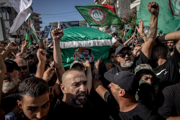 Men carry the coffin of Amal fighter, Ayman Kamel Idriss who was killed in an Israeli strike in southern Lebanon on Aug. 25, during his funeral on Aug. 26, 2024 Nabatieh, Lebanon. The recent assassination of a Hezbollah military commander in Lebanon, as well as the killing of the political leader of Hamas in Iran, has heightened concerns of a wider regional war between Israel and Iran-backed enemies like Hezbollah. Israel and Hezbollah have traded regular cross-border fire since Oct. 7, although both sides have seemed to calculate their attacks to avoid all-out war. (Chris McGrath/Getty Images)