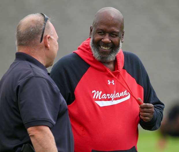 Maryland coach Mike Locksley speaks with security during practice. (Kenneth K. Lam/Baltimore Sun)