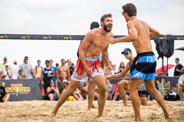 David Wieczorek, center, celebrates with partner Jordan Hoppe after scoring a point in the AVP Chicago Open at Oak Street Beach in Chicago on Aug. 30, 2024. (Tess Crowley/Chicago Tribune)