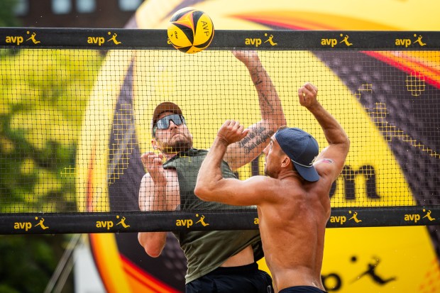 Trevor Crabb, right, attempts to spike a ball hit by Cerutti Alison in the AVP Chicago Open at Oak Street Beach in Chicago on Aug. 30, 2024. (Tess Crowley/Chicago Tribune)