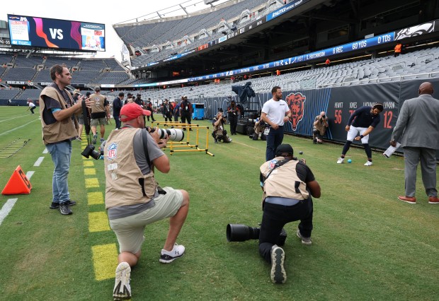 Photographers surround Bears quarterback Caleb Williams as he begins stretching for a preseason game against the Bengals at Soldier Field on Aug. 17, 2024, in Chicago. (John J. Kim/Chicago Tribune)