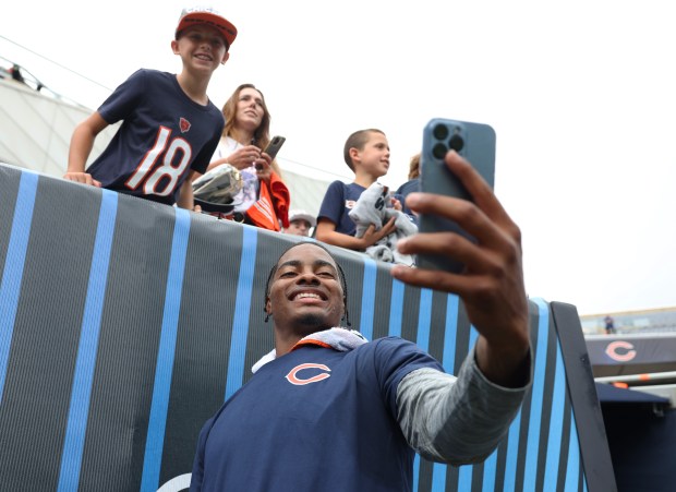 Bears safety Jaquan Brisker takes a selfie photograph with a fan before a preseason game against the Bengals at Soldier Field on Aug. 17, 2024, in Chicago. (John J. Kim/Chicago Tribune)