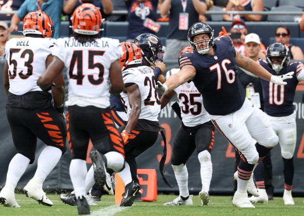 Bears guard Teven Jenkins (76) looks behind him as quarterback Caleb Williams (18), center, rushes for a touchdown in the second quarter against the Bengals in a preseason game at Soldier Field on Aug. 17, 2024, in Chicago. (John J. Kim/Chicago Tribune)