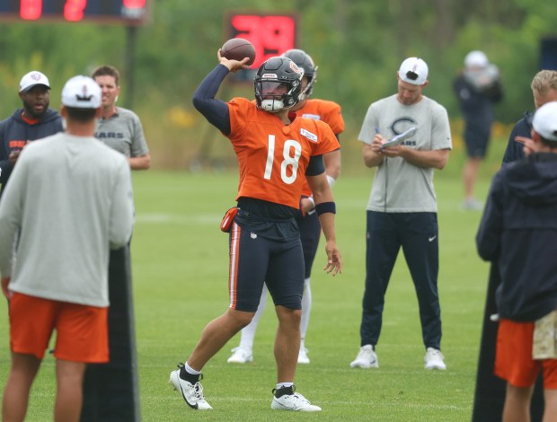 Bears quarterback Caleb Williams tosses a ball back to a coach after throwing an interception to Bengals linebacker Germaine Pratt during practice at Halas Hall on Aug. 15, 2024, in Lake Forest. (Stacey Wescott/Chicago Tribune)