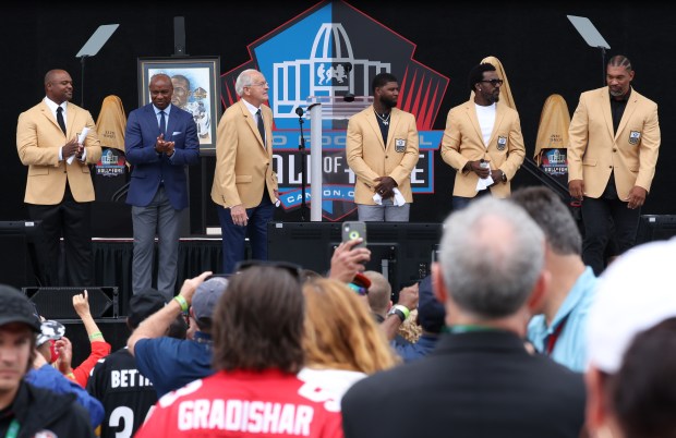 Inductees of the 2024 Pro Football Hall of Fame, including Jarrett Payton representing Steve McMichael, second from left, take the stage for the enshrinement ceremony at Tom Benson Hall of Fame Stadium on Aug. 3, 2024, in Canton. (John J. Kim/Chicago Tribune)