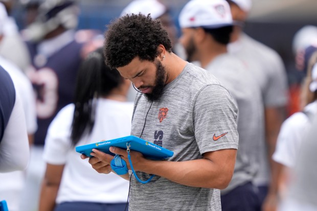 Bears quarterback Caleb Williams reviews a play on a tablet during a preseason game Saturday, Aug. 17, 2024, at Soldier Field. (AP Photo/Charles Rex Arbogast)