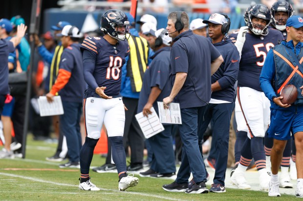 Bears quarterback Caleb Williams talks with offensive coordinator Shane Waldron during the first half of a preseason game against the Bengals on Saturday, Aug. 17, 2024, at Soldier Field. (AP Photo/Kamil Krzaczynski)