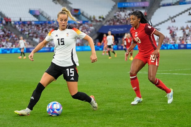 Germany's Giulia Gwinn, left, and Canada's Ashley Lawrence participate in a women's quarterfinal soccer match between Canada and Germany on Aug. 3. Germany won 4-2 (0-0) in penalty kicks. (AP Photo/Julio Cortez)