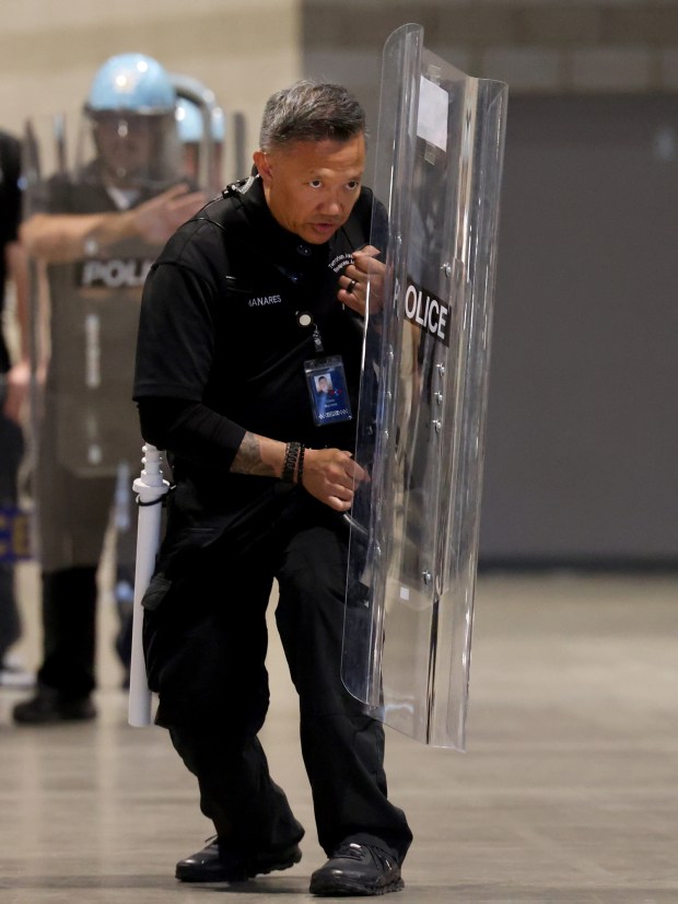 A trainer instructs police officers how to use their shields to protect themselves and keep back demonstrators who might push through the line as the Chicago Police Department trains at McCormick Place, June 6, 2024, for the Democratic National Convention. (Antonio Perez/Chicago Tribune)