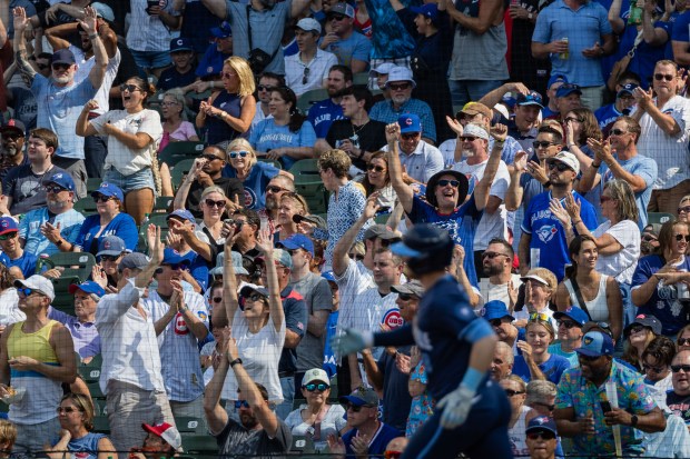 Fans cheer after Chicago Cubs left fielder Ian Happ (8) hits a home run in the seventh inning against the Toronto Blue Jays at Wrigley Field in Chicago on Aug. 16, 2024. The Cubs won 6-5 against the Toronto Blue Jays. (Tess Crowley/Chicago Tribune)