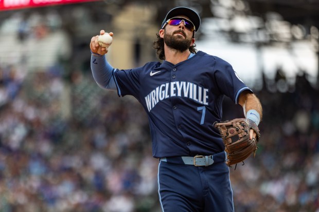 Chicago Cubs shortstop Dansby Swanson (7) throws a ball to fans during the tenth inning against the Toronto Blue Jays at Wrigley Field in Chicago on Aug. 16, 2024. The Cubs won 6-5 against the Toronto Blue Jays. (Tess Crowley/Chicago Tribune)