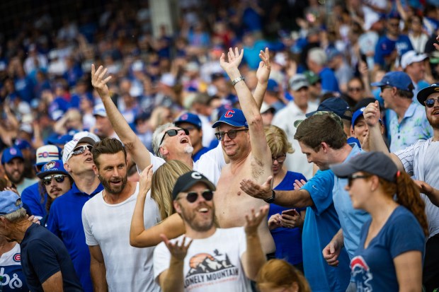 Fans celebrate after Chicago Cubs designated hitter Seiya Suzuki (27) singles on a ground ball to Toronto Blue Jays left fielder Joey Loperfido (9) allowing Chicago Cubs left fielder Ian Happ (8) to score in the tenth inning bringing the score to 6-5 against the Toronto Blue Jays at Wrigley Field in Chicago on Aug. 16, 2024. The Cubs won 6-5 against the Toronto Blue Jays. (Tess Crowley/Chicago Tribune)