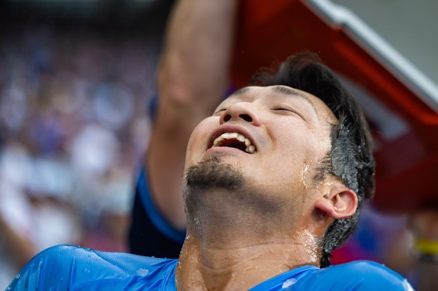 Chicago Cubs designated hitter Seiya Suzuki (27) receives a Gatorade bath after singling on a ground ball to Toronto Blue Jays left fielder Joey Loperfido (9) allowing Chicago Cubs left fielder Ian Happ (8) to score in the tenth inning bringing the score to 6-5 against the Toronto Blue Jays at Wrigley Field in Chicago on Aug. 16, 2024. The Cubs won 6-5 against the Toronto Blue Jays. (Tess Crowley/Chicago Tribune)