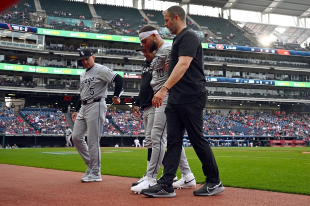 White Sox third baseman Yoán Moncada is helped off the field after suffering an injury against the Guardians on April 9, 2024, at Progressive Field in Cleveland. (Jason Miller/Getty)