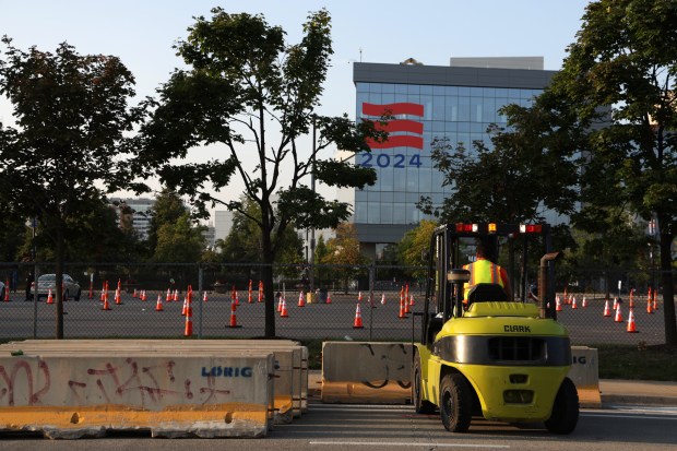 Workers gather barriers on roadways as streets around the United Center open on Aug. 23, 2024, following this week's Democratic National Convention. (Stacey Wescott/Chicago Tribune)