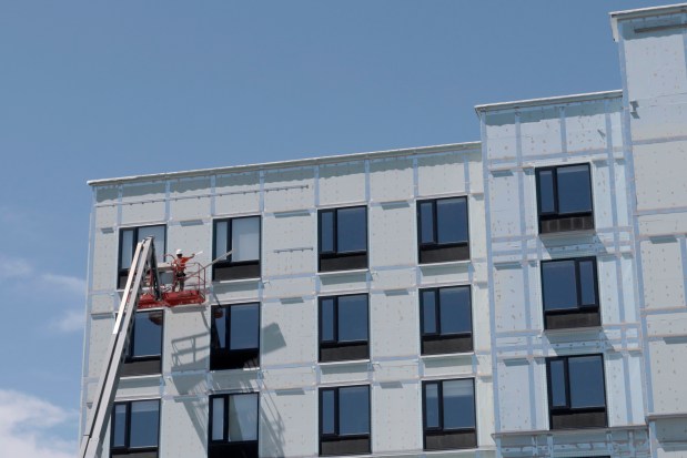 A worker works on the front facade of the new Hampton Inn and Suites in the Medical District in Chicago, Friday, Aug. 9, 2024, ahead of the DNC in Chicago. DNC is helping the Chicago hotel market end the summer tourist season on a high note. (Antonio Perez/Chicago Tribune)