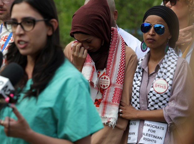 U.S. Rep. Ilhan Omar, right, comforts Asma Nizami, an uncommitted delegate from Minnesota, as they listen to Dr. Tammy Abughnaim speak about the atrocities she's witnessed while working in Gaza, at Park 578 on Aug. 21. 2024, in Chicago. Dr. Abughnaim and others gathered to ask Democratic leaders to stop supplying weapons to Israel. (Stacey Wescott/Chicago Tribune)