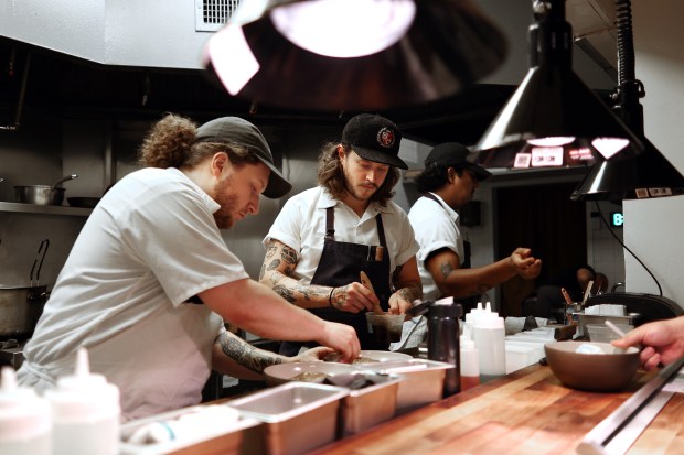 Nate Tryman, left, and Jackson Cretin prepare orders at John's Food and Wine. (Terrence Antonio James/Chicago Tribune)