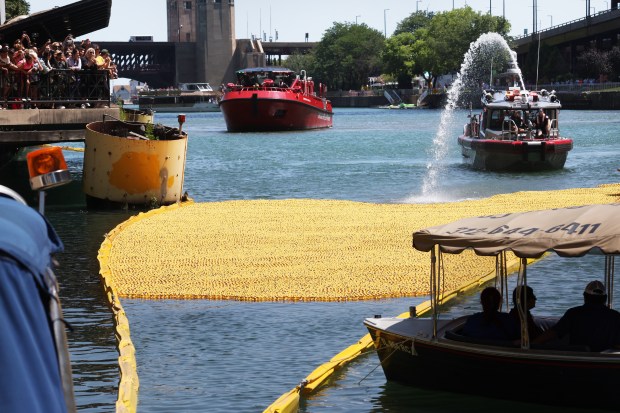 A Chicago Fire Department boat nudges rubber ducks towards the finish line of the 2024 Chicago Ducky Derby on the Chicago River at the Columbus Drive Bridge in Chicago on Aug. 7, 2024. (Terrence Antonio James/Chicago Tribune)