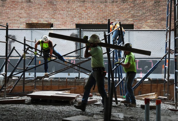 Construction crews work on a new 29-floor residential building being built by Clayco at 220 North Ada on Aug. 2, 2024, in Chicago. 24 EV charging stations are planned for the apartment building. (Stacey Wescott/Chicago Tribune)