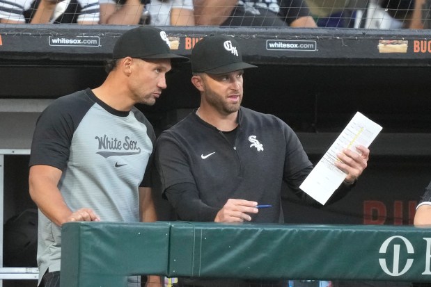 White Sox interim manager Grady Sizemore, left, listens to pitching coach Tommy Hottovy in the dugout during the fourth inning against the Cubs on Saturday, Aug. 10, 2024. (AP Photo/Charles Rex Arbogast)