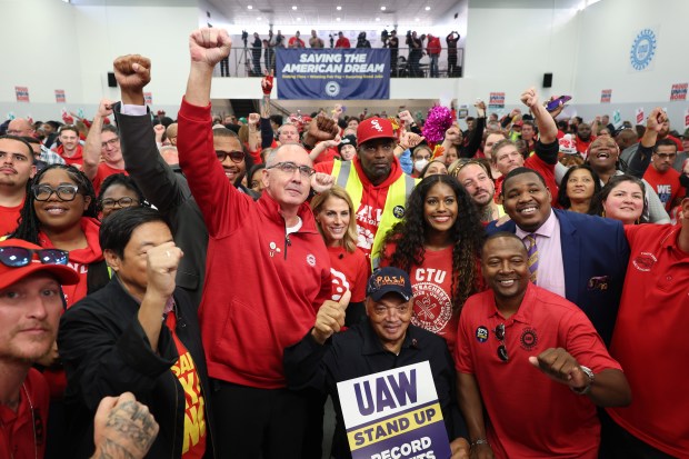 United Auto Workers President Shawn Fain, center left, stands for pictures with the Rev. Jesse Jackson, bottom center, after a rally for striking workers at UAW Local 551 on Oct. 7, 2023, in Chicago. (John J. Kim/Chicago Tribune)