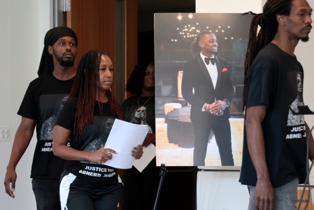 Family members of Abnerd Joseph walk past a photo of Joseph as they arrive at a news conference at the law offices of Romanucci and Blandin in Chicago on Aug. 26, 2024.