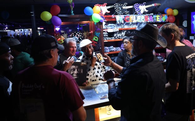 Buddy Guy poses for a photograph with a fan as he signs autographs during his 88th birthday celebration at his Buddy Guy's Legends music club on July 31, 2024. (Chris Sweda/Chicago Tribune)