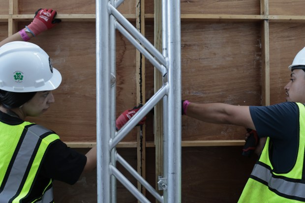 Local Union 1 Carpenters Jaclyn Ramirez, left, and Joe Villareal put together two large panels of a large mural of Vice-President Kamala Harris outside the United Center on Aug. 16, 2024, in Chicago. (Antonio Perez/Chicago Tribune)