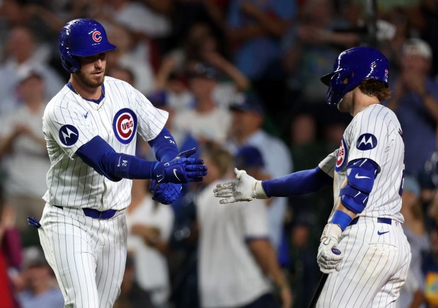 Chicago Cubs designated hitter Cody Bellinger (left) is congratulated by teammate Nico Hoerner after Bellinger hit a solo home run in the ninth inning of a game against the St. Louis Cardinals at Wrigley Field in Chicago on Aug. 1, 2024. (Chris Sweda/Chicago Tribune)