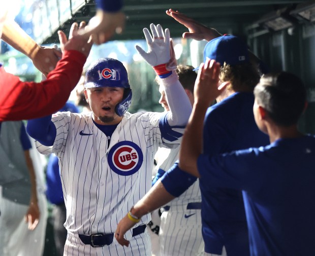 Chicago Cubs outfielder Seiya Suzuki (27) is congratulated by his teammates in the dugout after hitting a solo home run in the sixth inning of a game against the St. Louis Cardinals at Wrigley Field in Chicago on Aug. 1, 2024. (Chris Sweda/Chicago Tribune)